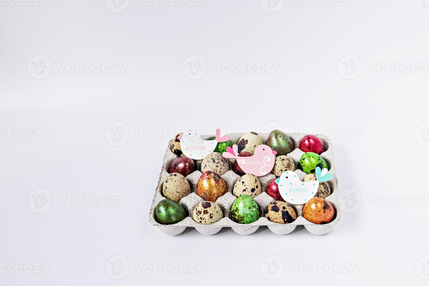 Colored quail Easter eggs in a box on the white background. Easter holiday concept photo