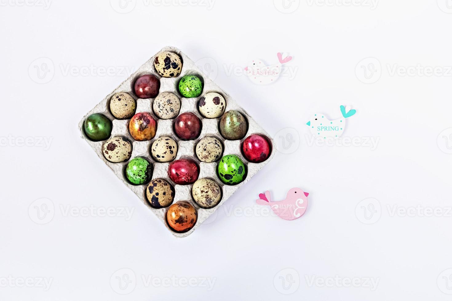 Colored quail Easter eggs in a box on the white background. Easter holiday concept photo