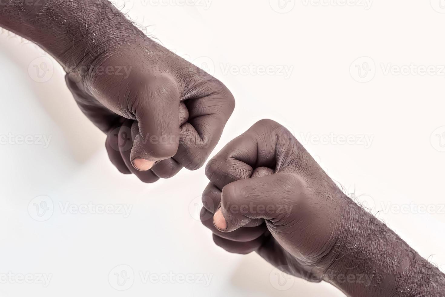 Male hand clenched into a fist on a white background. A symbol of the struggle for the rights of blacks in America. Protest against racism. photo