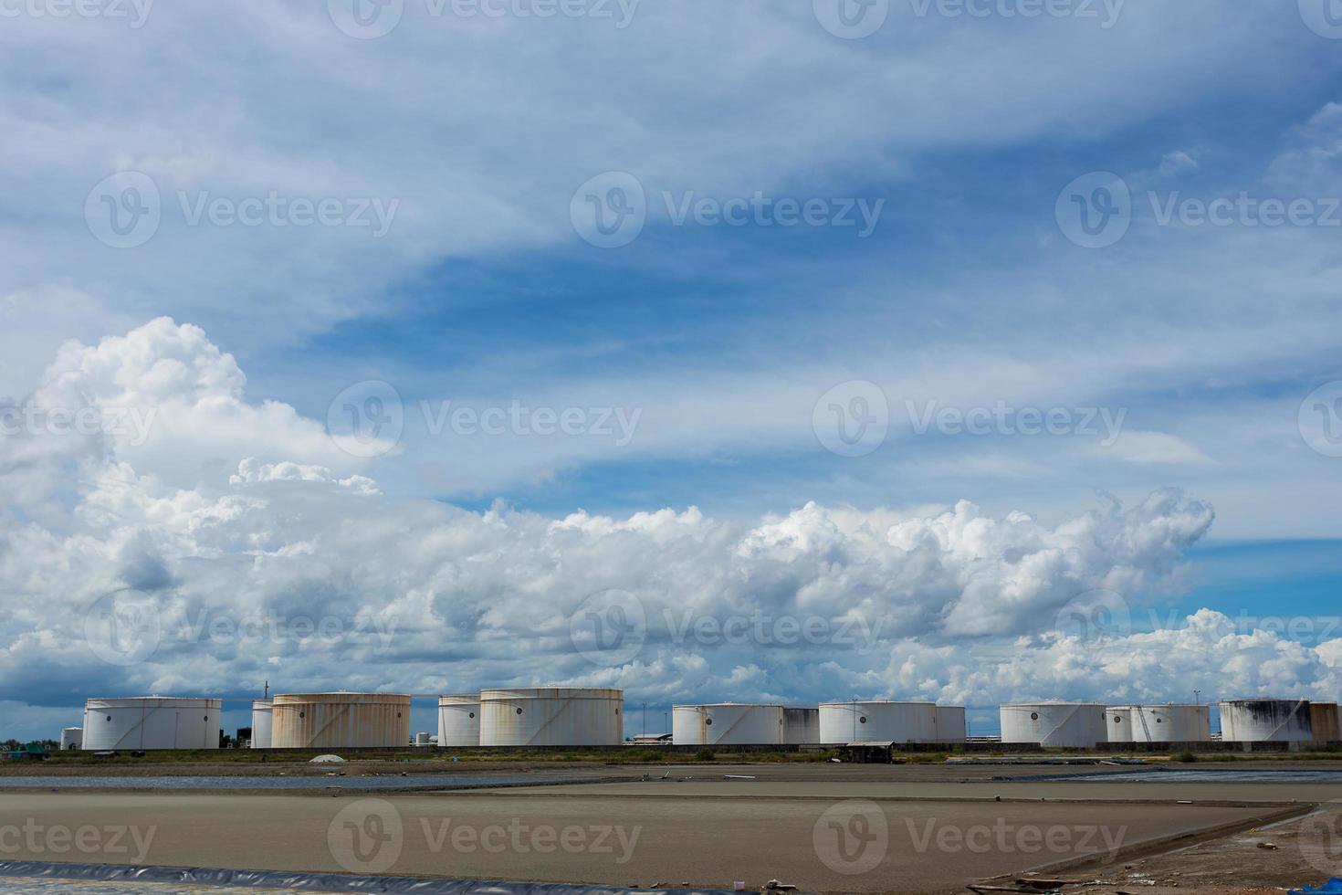 Tanques de aceite en una fila bajo un cielo azul foto