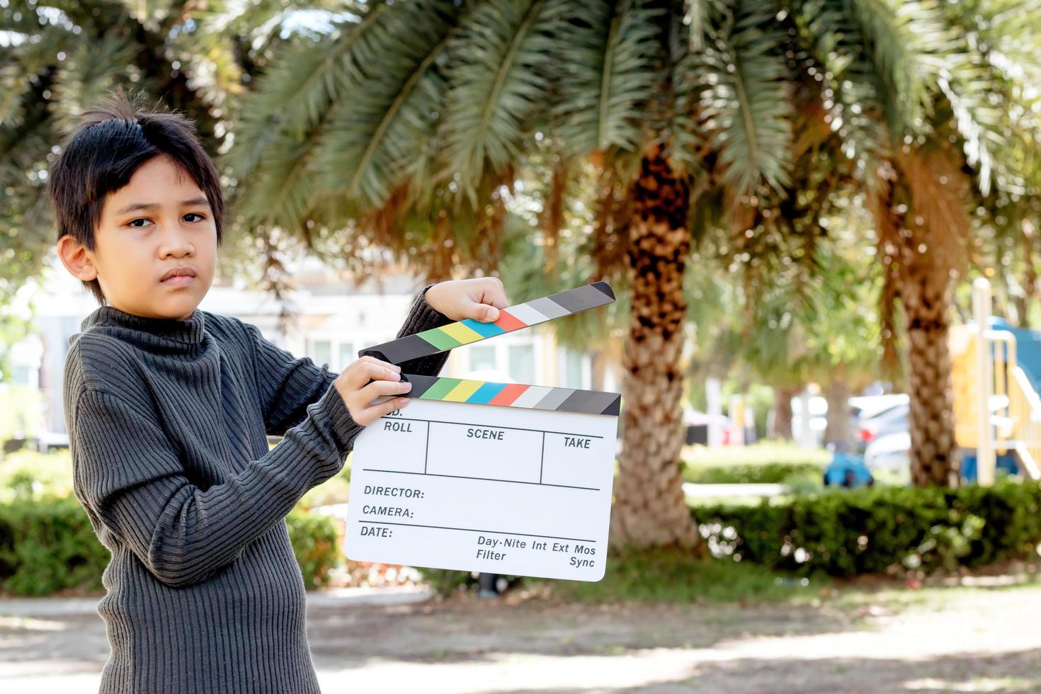 Chico asiático con tablero de colores de pizarra de película para la industria del cine y la televisión. foto