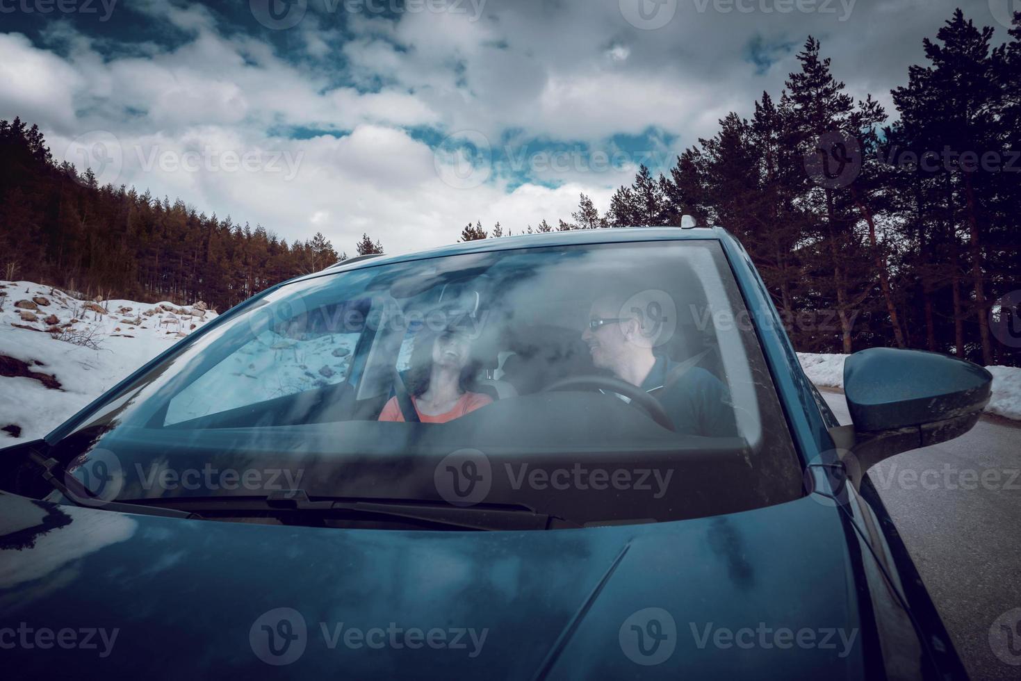 una pareja conduce en el elegante coche en un día nevado de invierno. foto