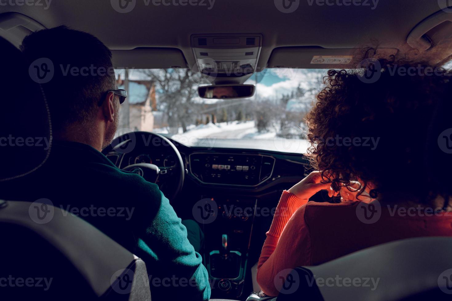 A couple drives in the fancy car at winter snowy day. photo