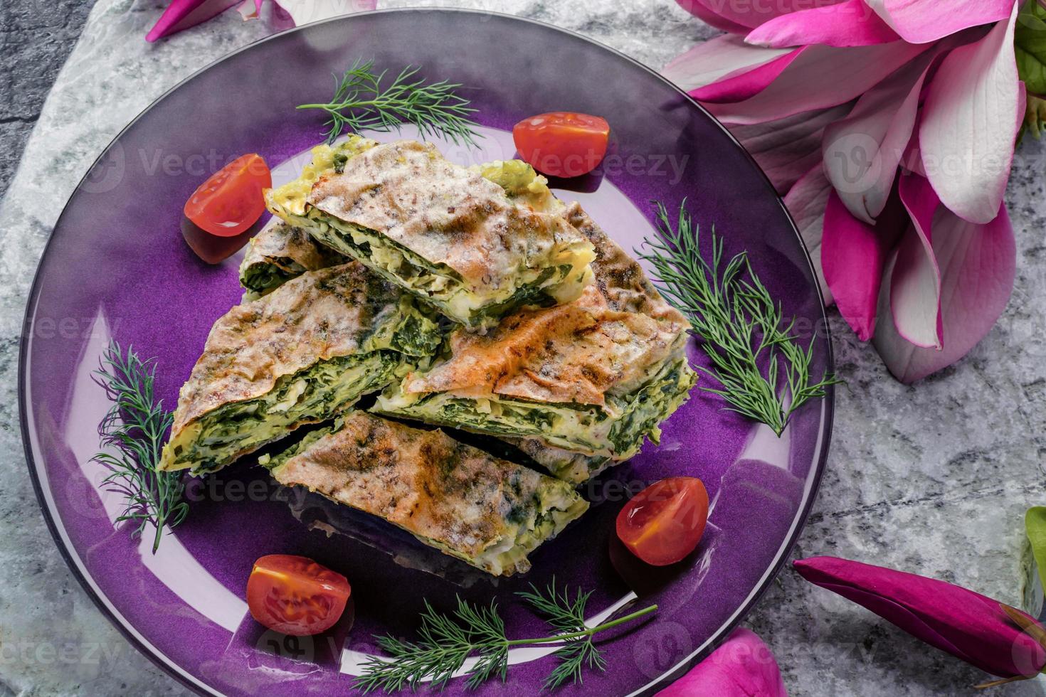 Spinach pie with cherry tomatoes prepared in the traditional way photo