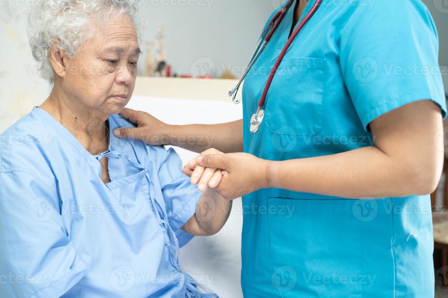 Tocar a la paciente asiática mayor o anciana con amor, cuidado, ayuda, aliento y empatía en la sala del hospital de enfermería concepto médico fuerte y saludable foto