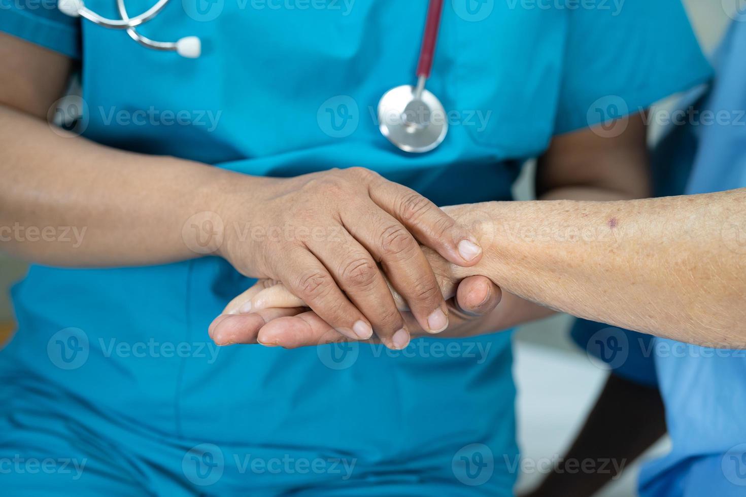 Tomados de la mano anciana asiática o anciana paciente con amor, cuidado, ánimo y empatía en la sala del hospital de enfermería, concepto médico fuerte y saludable foto