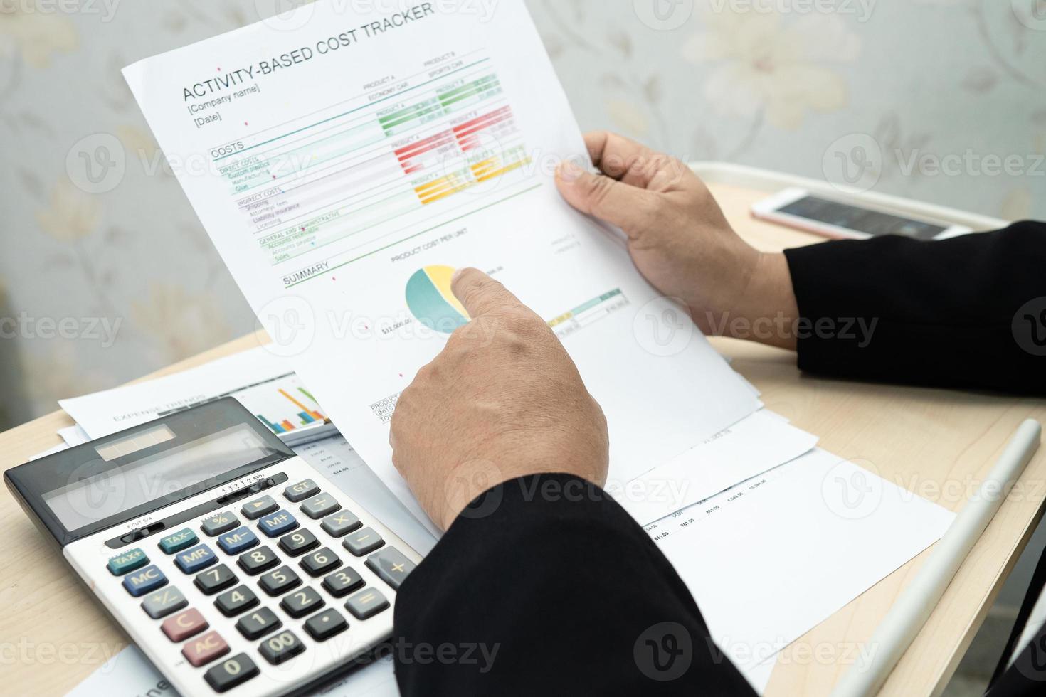 Contador asiático que trabaja y analiza la contabilidad del proyecto de los informes financieros con el gráfico y la calculadora en la oficina moderna, las finanzas y el concepto empresarial. foto