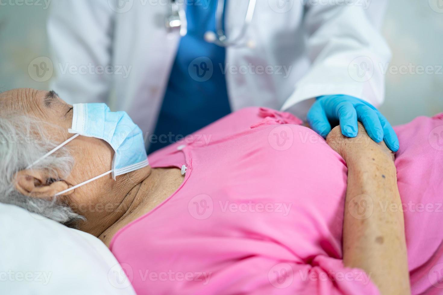 Doctor checking Asian senior or elderly old lady woman patient wearing a face mask in hospital for protect infection Covid-19 Coronavirus. photo