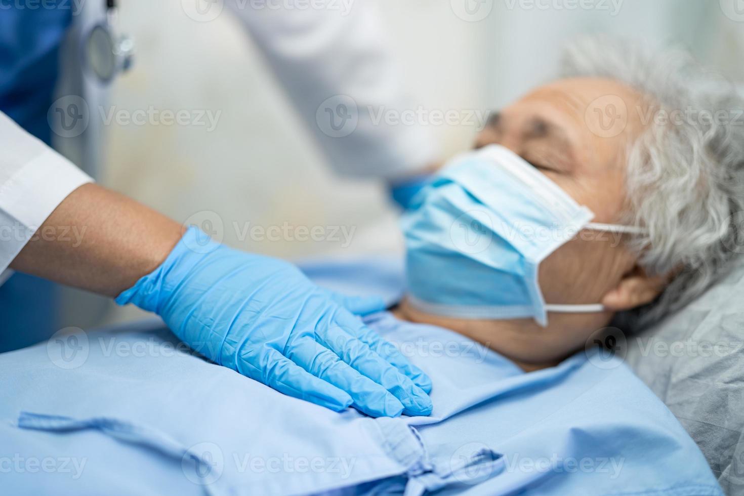 Asian doctor wearing PPE suit and glove new normal to check patient protect safety infection Covid-19 Coronavirus outbreak at quarantine nursing hospital ward. photo