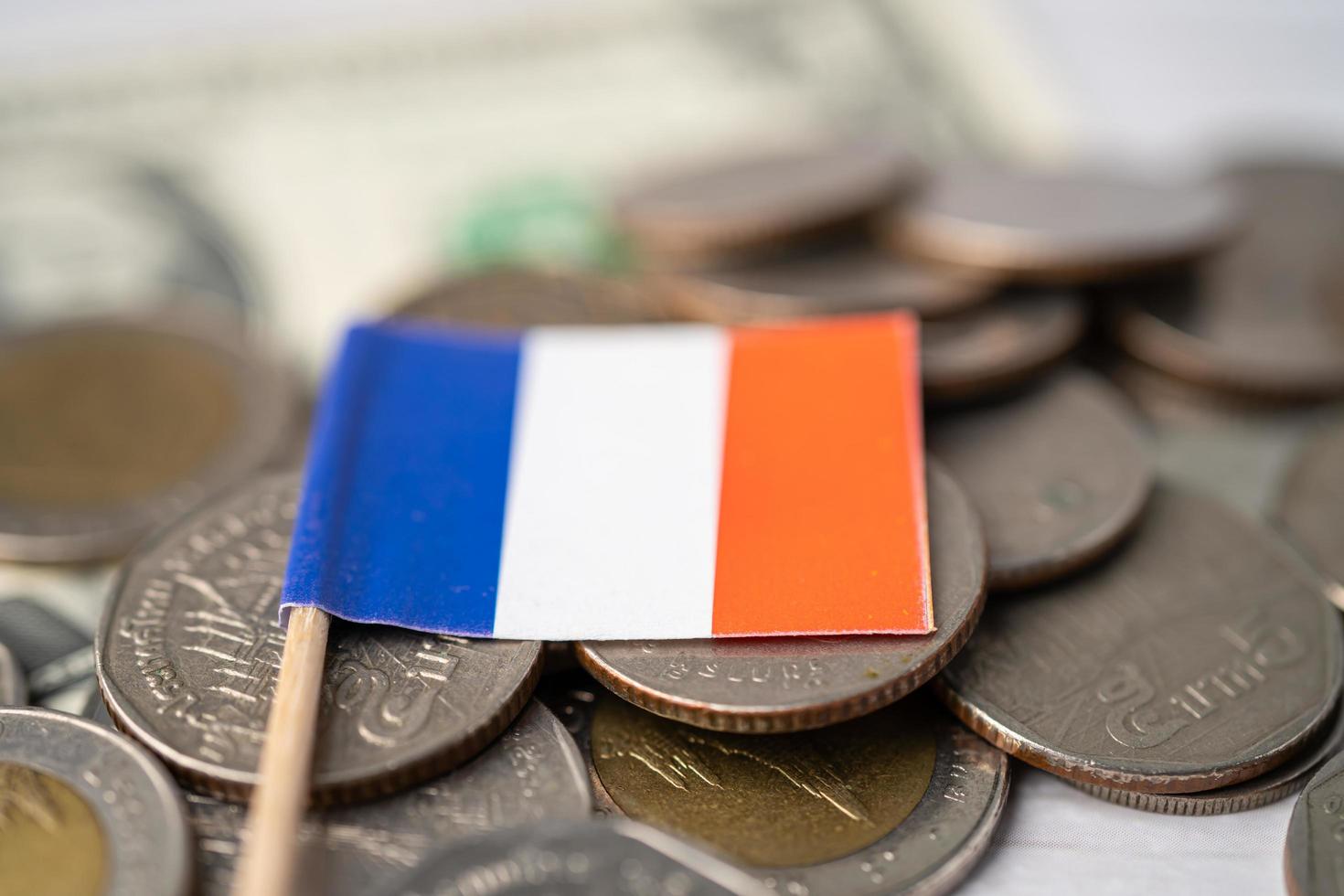 Stack of coins with France flag on USA America dollar banknotes. photo