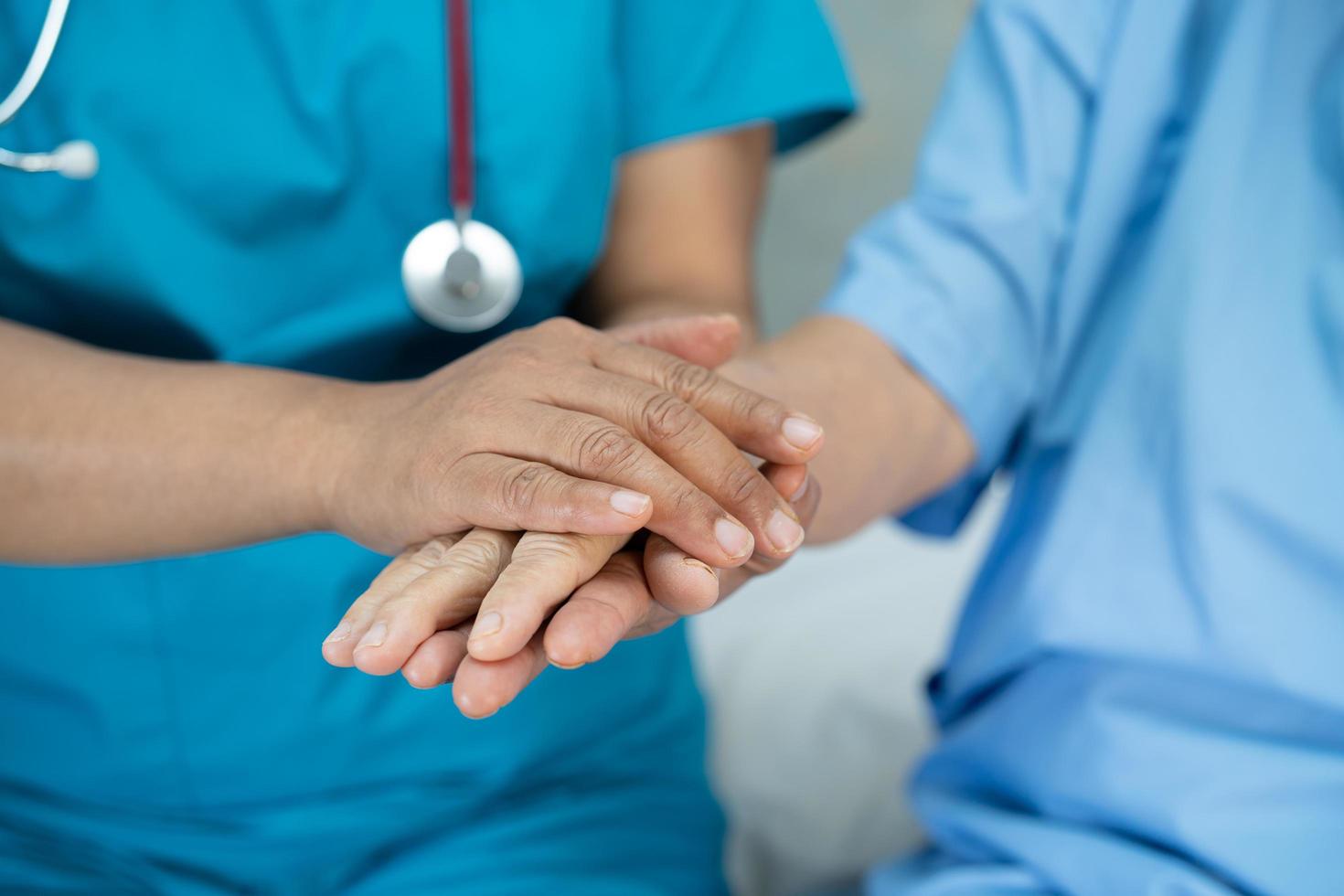 Tomados de la mano anciana asiática o anciana paciente con amor, cuidado, ánimo y empatía en la sala del hospital de enfermería, concepto médico fuerte y saludable foto