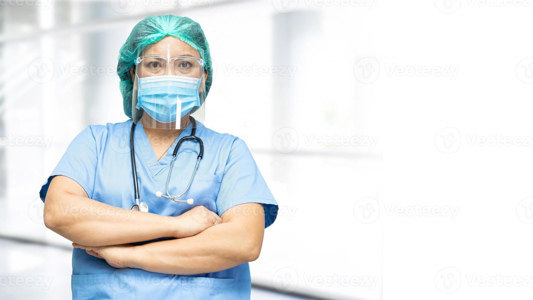 Asian doctor wearing face shield and PPE suit new normal to check patient protect safety infection Covid-19 Coronavirus outbreak at quarantine nursing hospital ward. photo