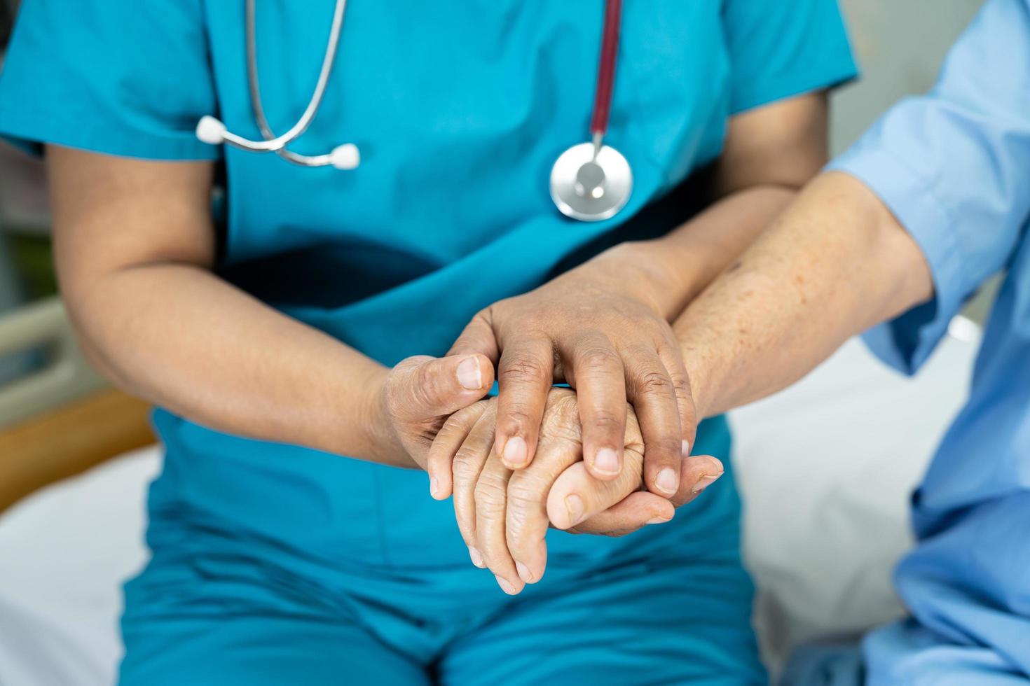 Tomados de la mano anciana asiática o anciana paciente con amor, cuidado, ánimo y empatía en la sala del hospital de enfermería, concepto médico fuerte y saludable foto