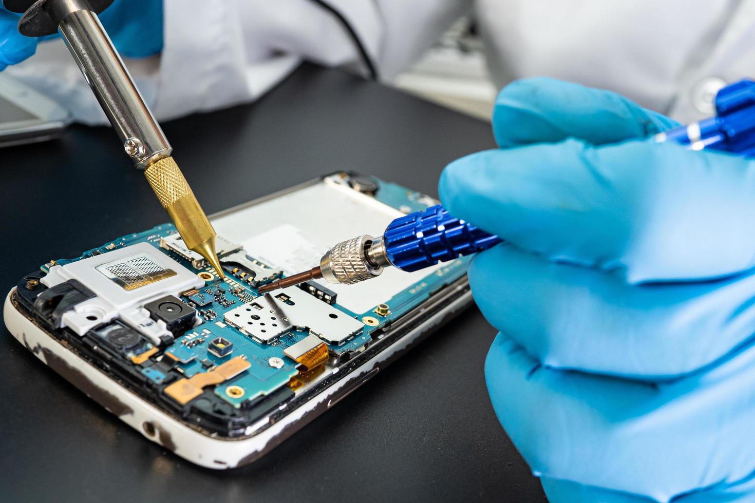Technician repairing inside of mobile phone by soldering iron. Integrated Circuit. the concept of data, hardware, technology. photo