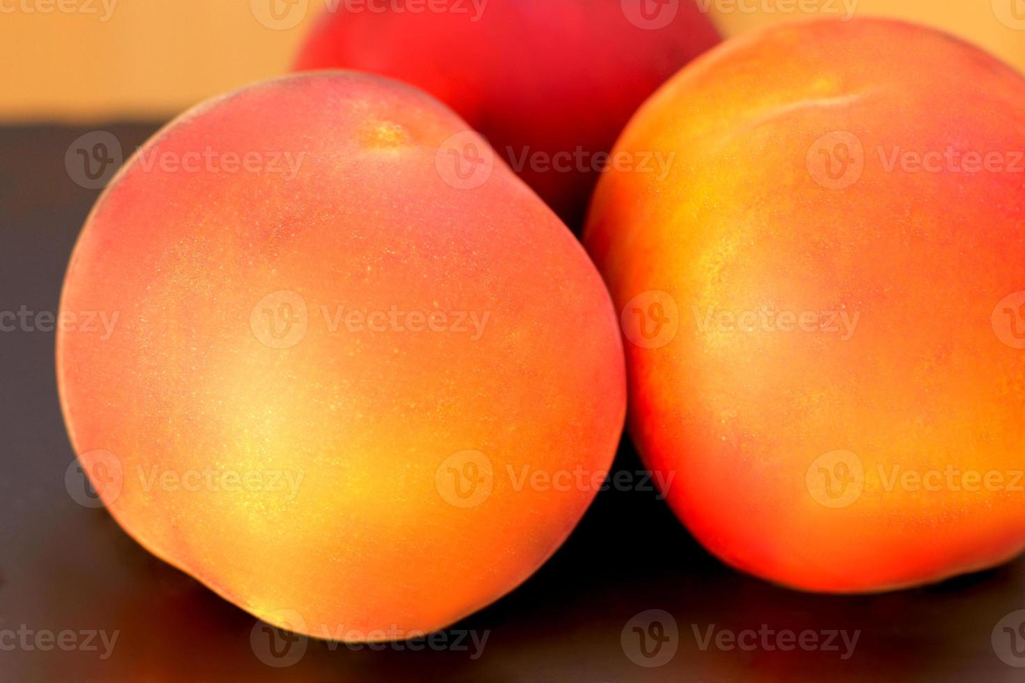 Ripe peach fruit, three peaches Prunus persica close up on black background photo