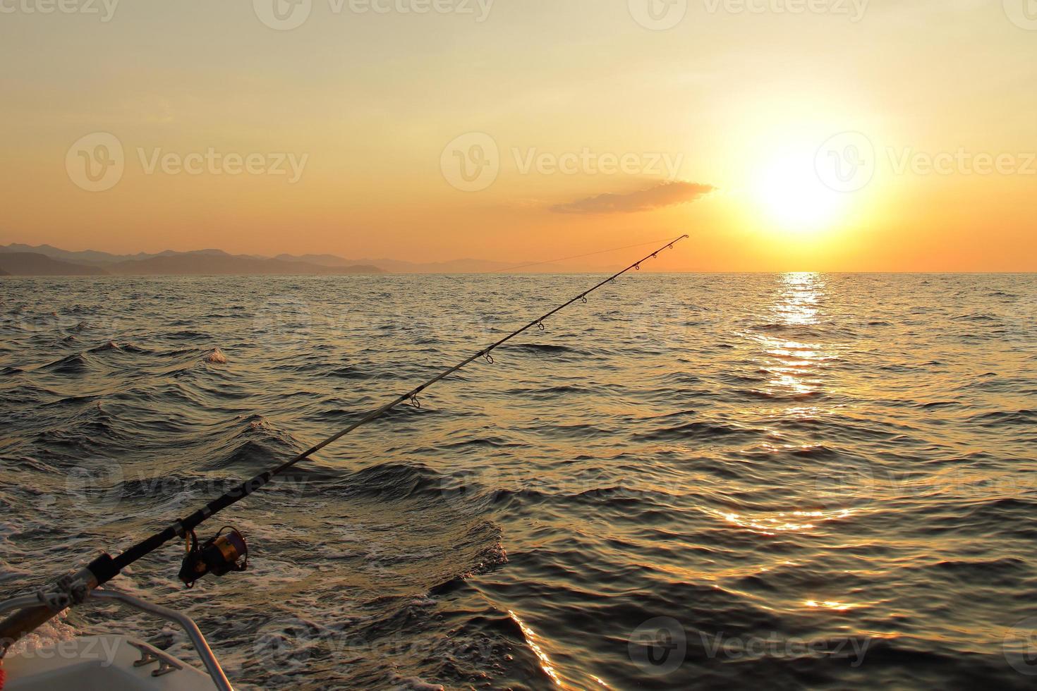 Fishing during sunset on ocean photo