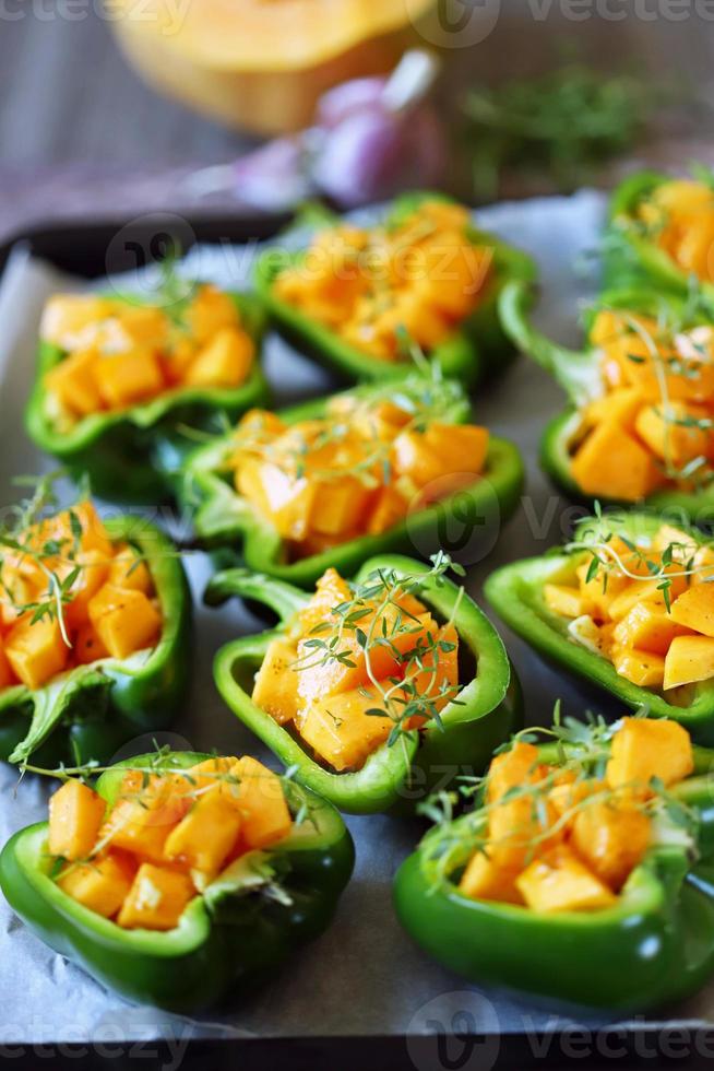 Green peppers stuffed with pumpkin pieces photo