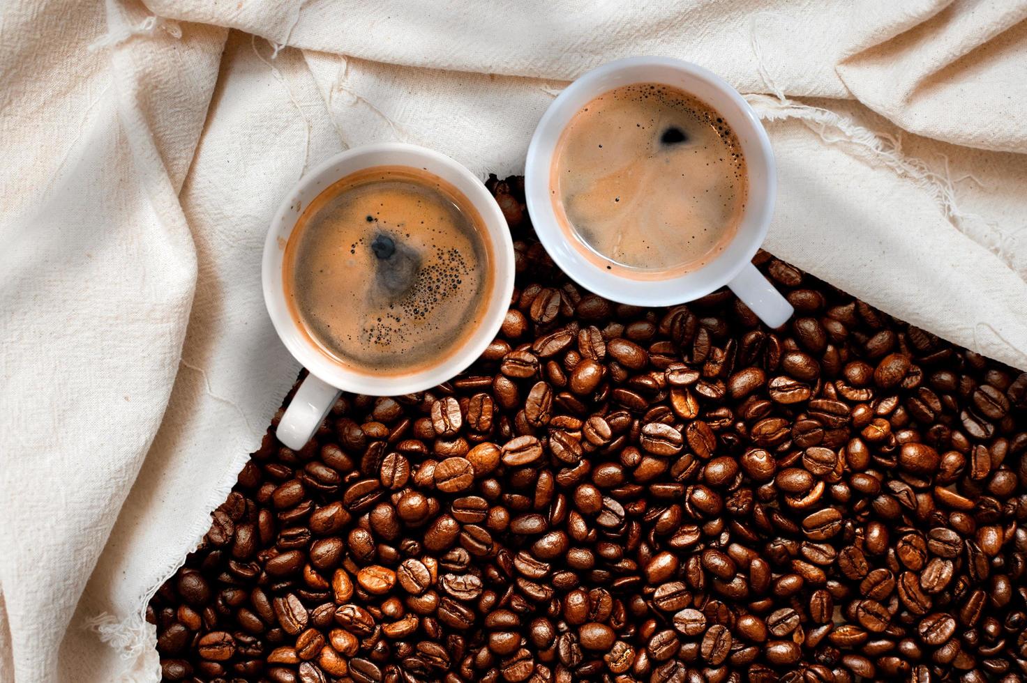 Cup of coffee with coffee beans on table photo