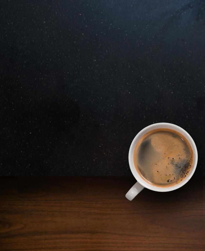 Cup of coffee with coffee beans on table photo