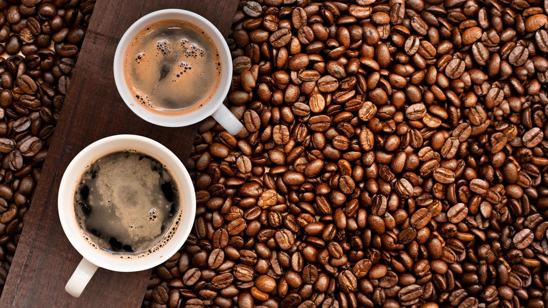 Cup of coffee with coffee beans on table photo