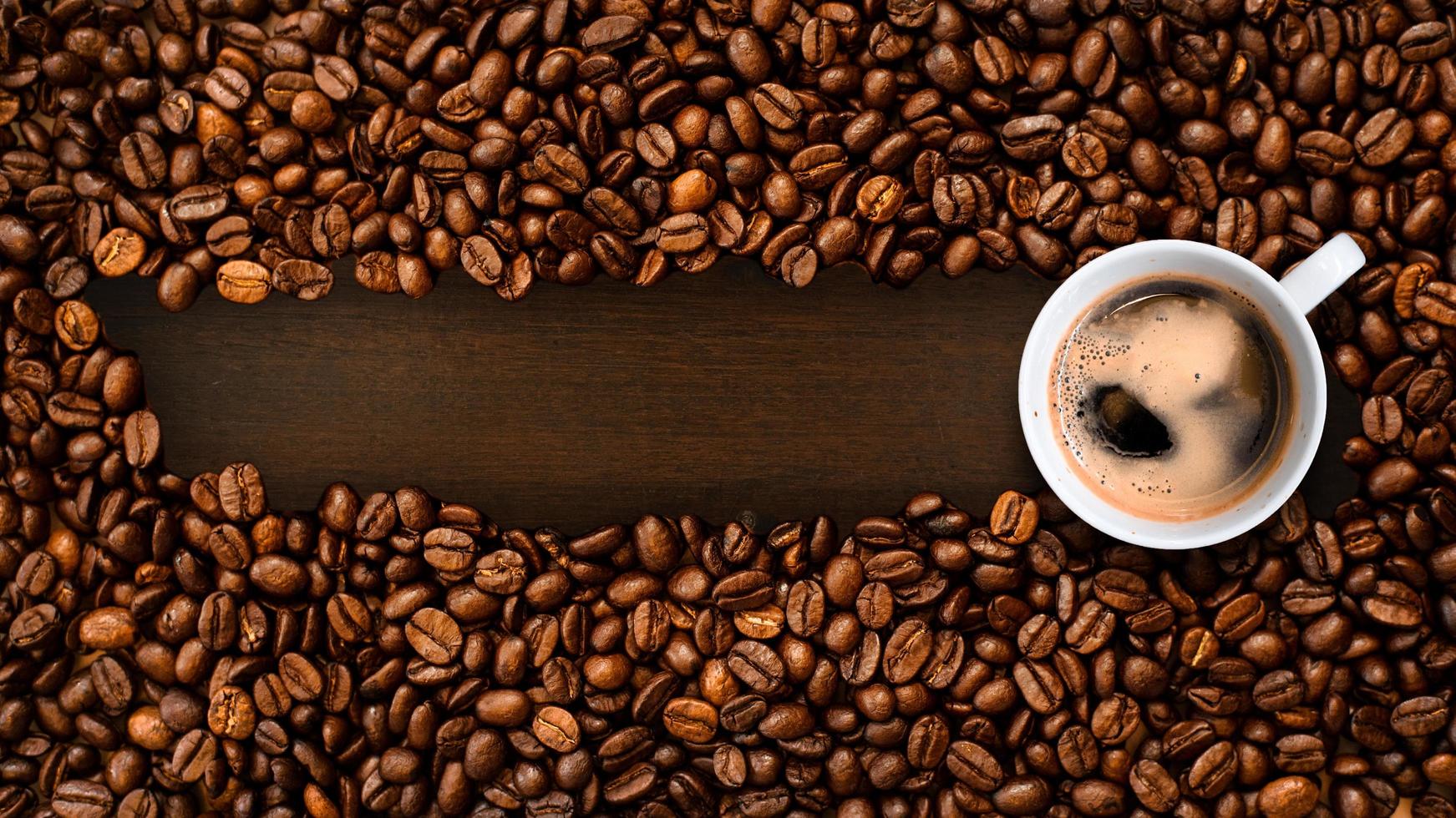 Cup of coffee with coffee beans on table photo