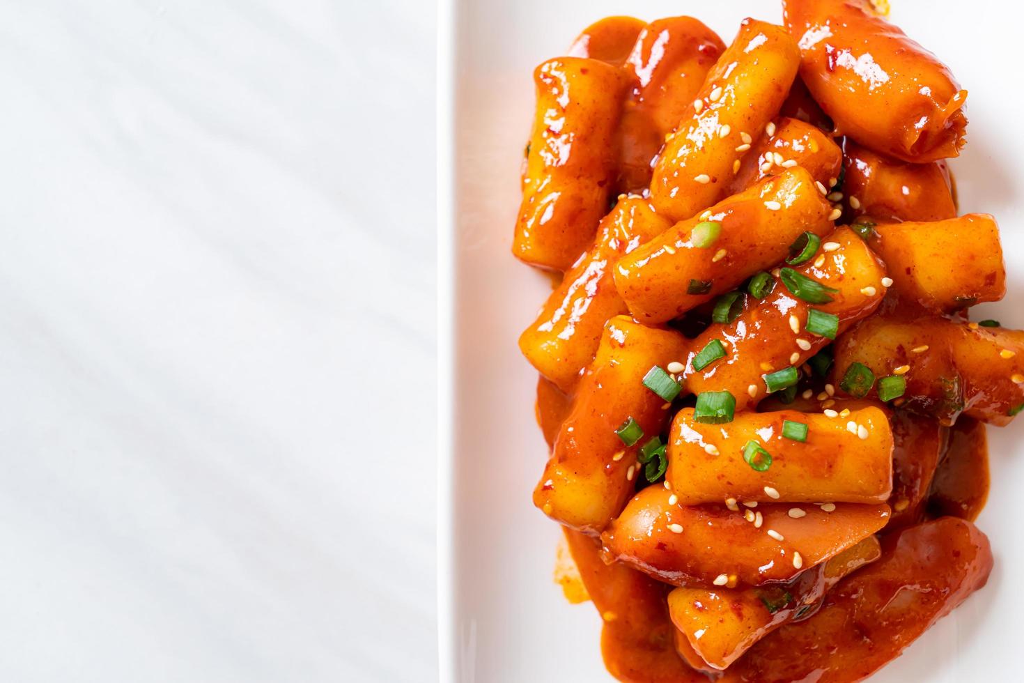 Korean rice cake stick with sausage in spicy sauce - Tteokbokki photo