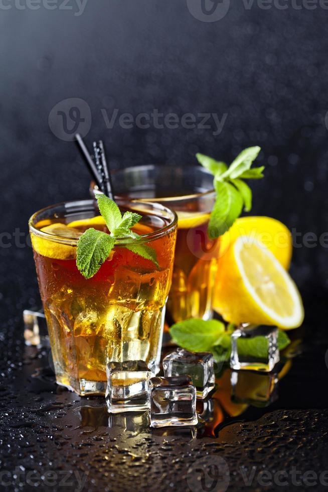 dos vasos con té helado tradicional frío con limón, hojas de menta y cubitos de hielo. foto