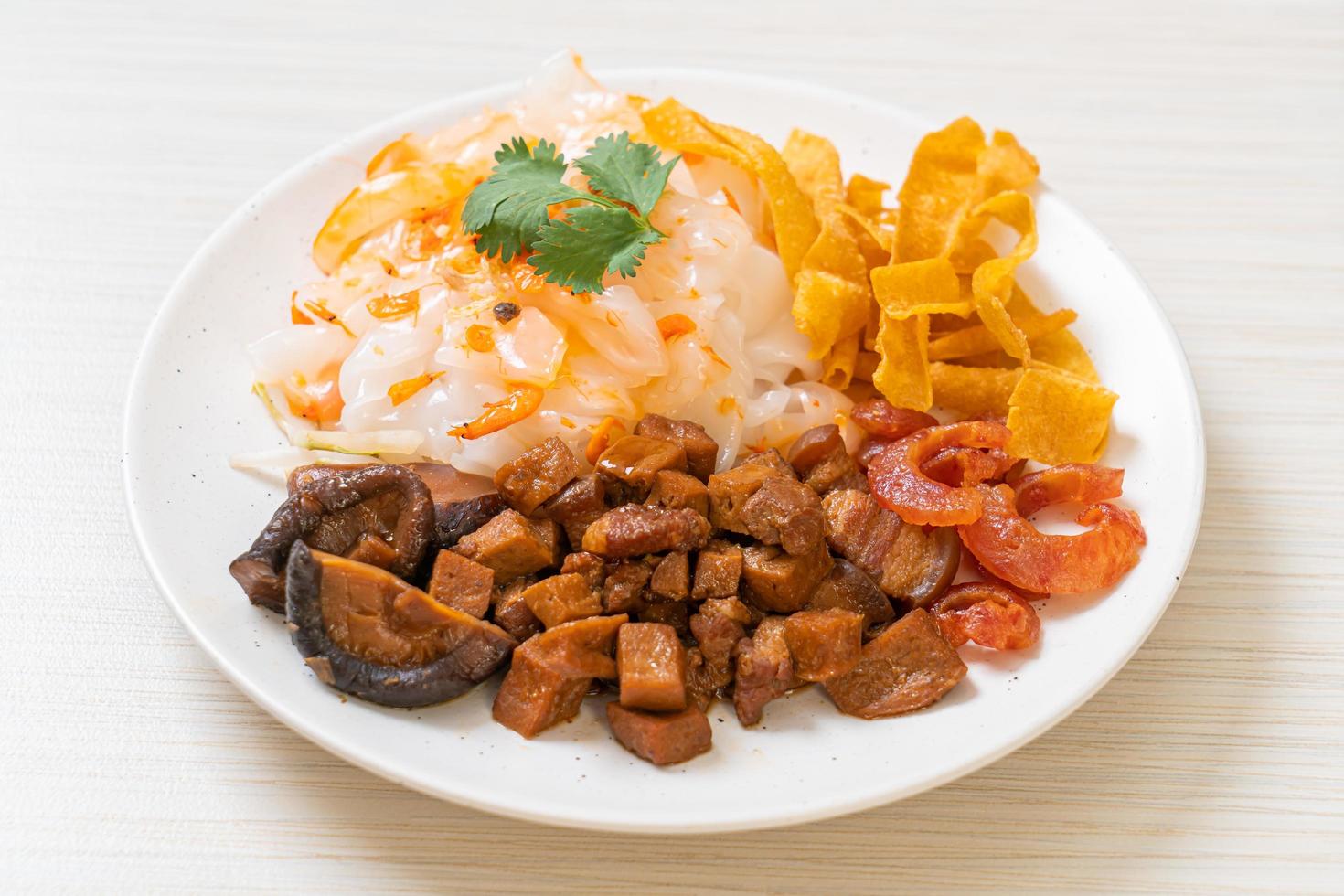 Fideos chinos de arroz al vapor con cerdo y tofu en salsa de soja dulce foto