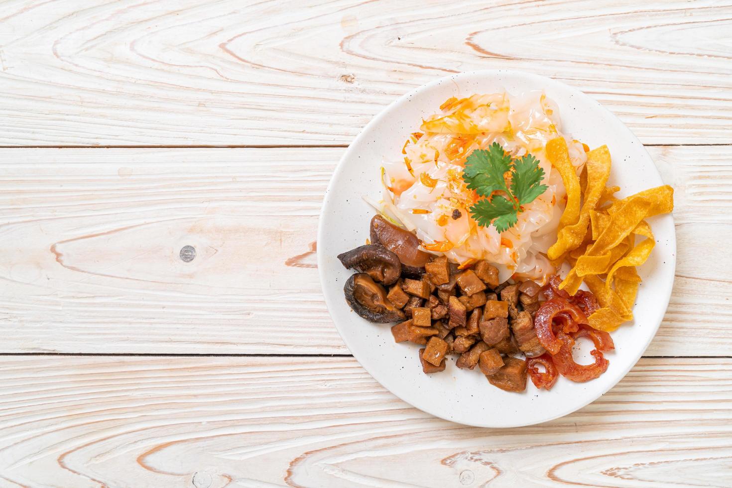 Fideos chinos de arroz al vapor con cerdo y tofu en salsa de soja dulce foto