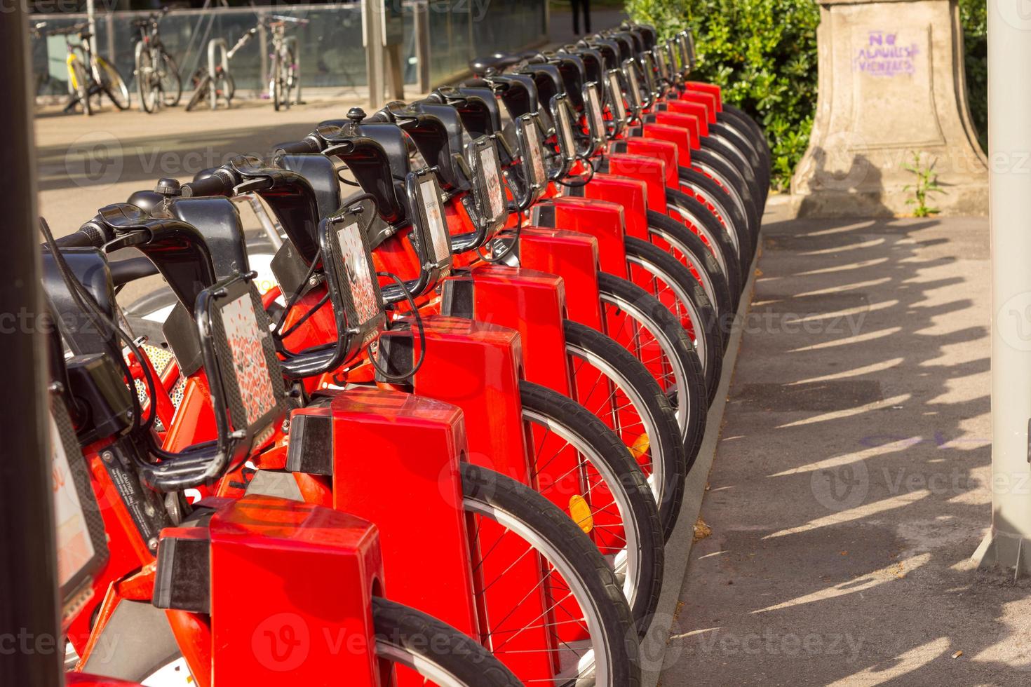 Servicio de alquiler de bicicletas en el estacionamiento de la carretera de la ciudad con luz solar, concepto de transporte público. foto