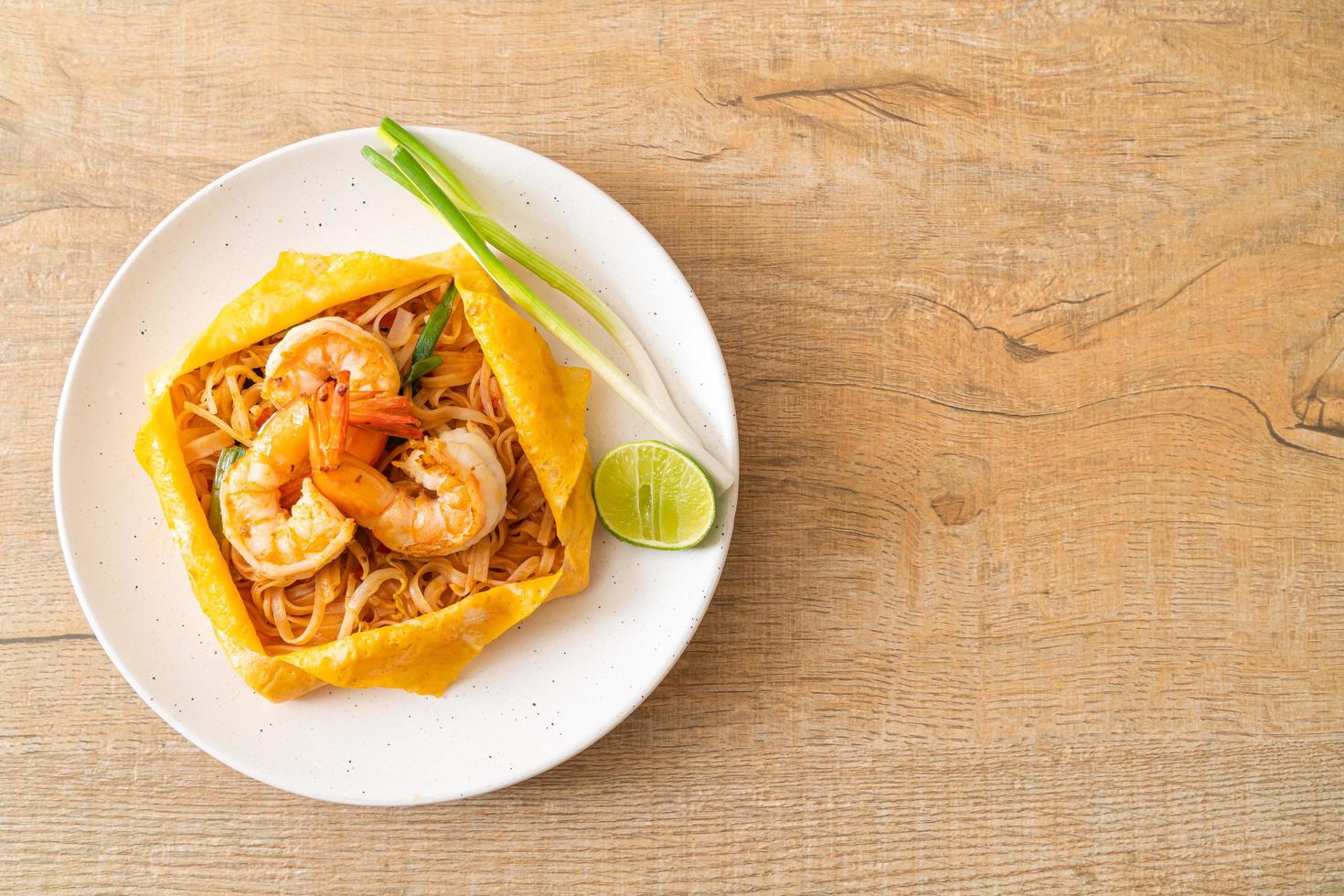 Thai stir fried noodles with shrimps and egg wrap photo