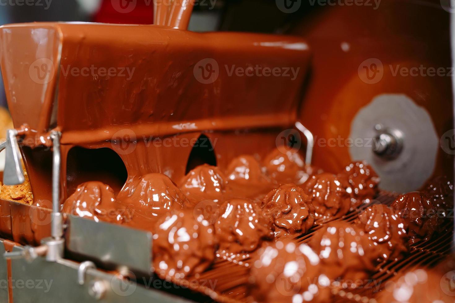 concepto de industria y producción de dulces - procesamiento de caramelos de chocolate en el transportador en la tienda de confitería. foto