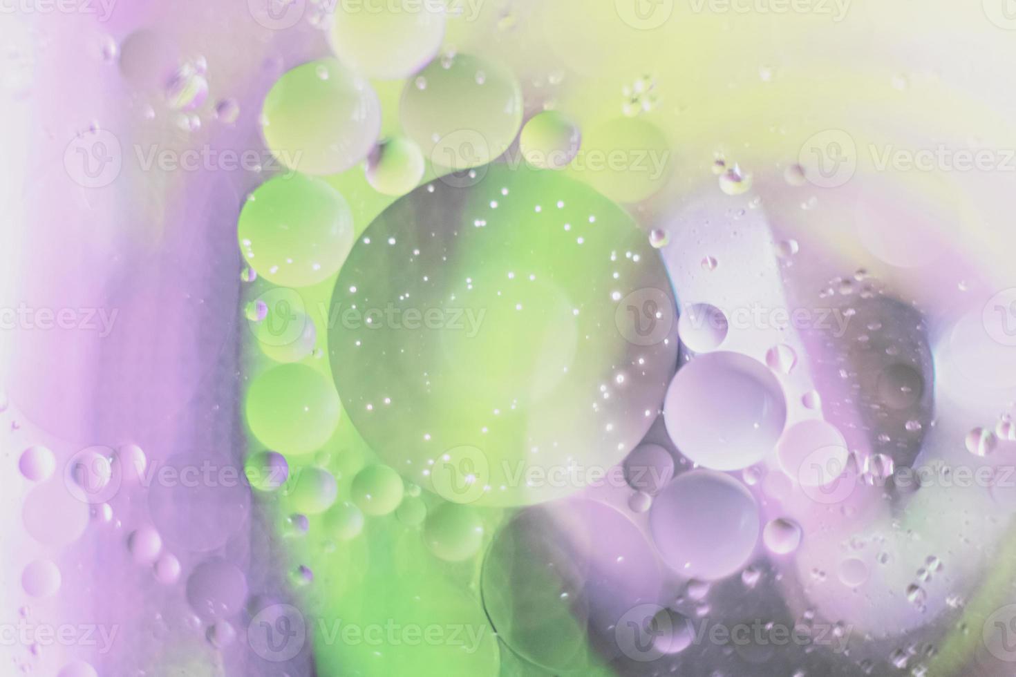 Macro photo of oil droplets on a green purple blurred background