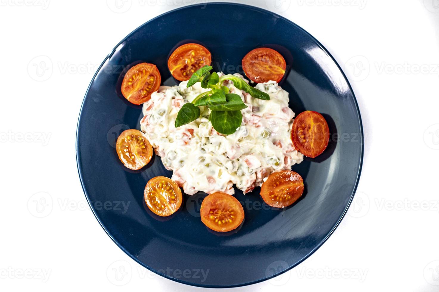 Russian salad on blue plate photo