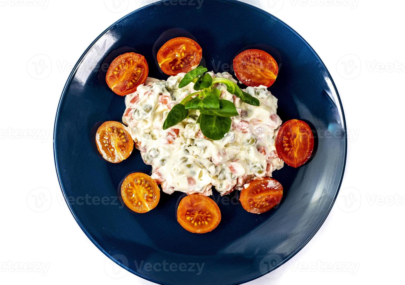 Russian salad on blue plate photo