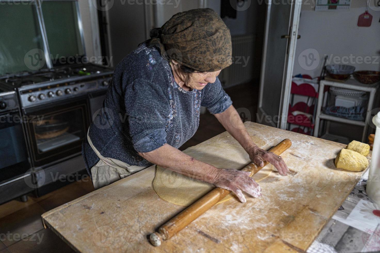 grandmother rolling out the freshly kneaded dough photo