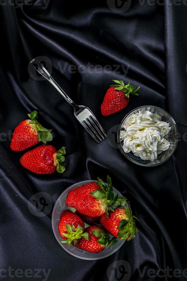 cup of ripe strawberries with cream photo