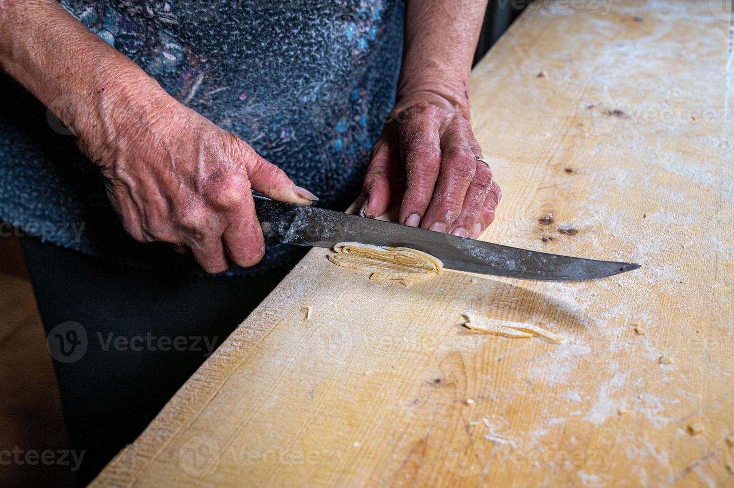 abuela prepara pasta de huevo casera foto