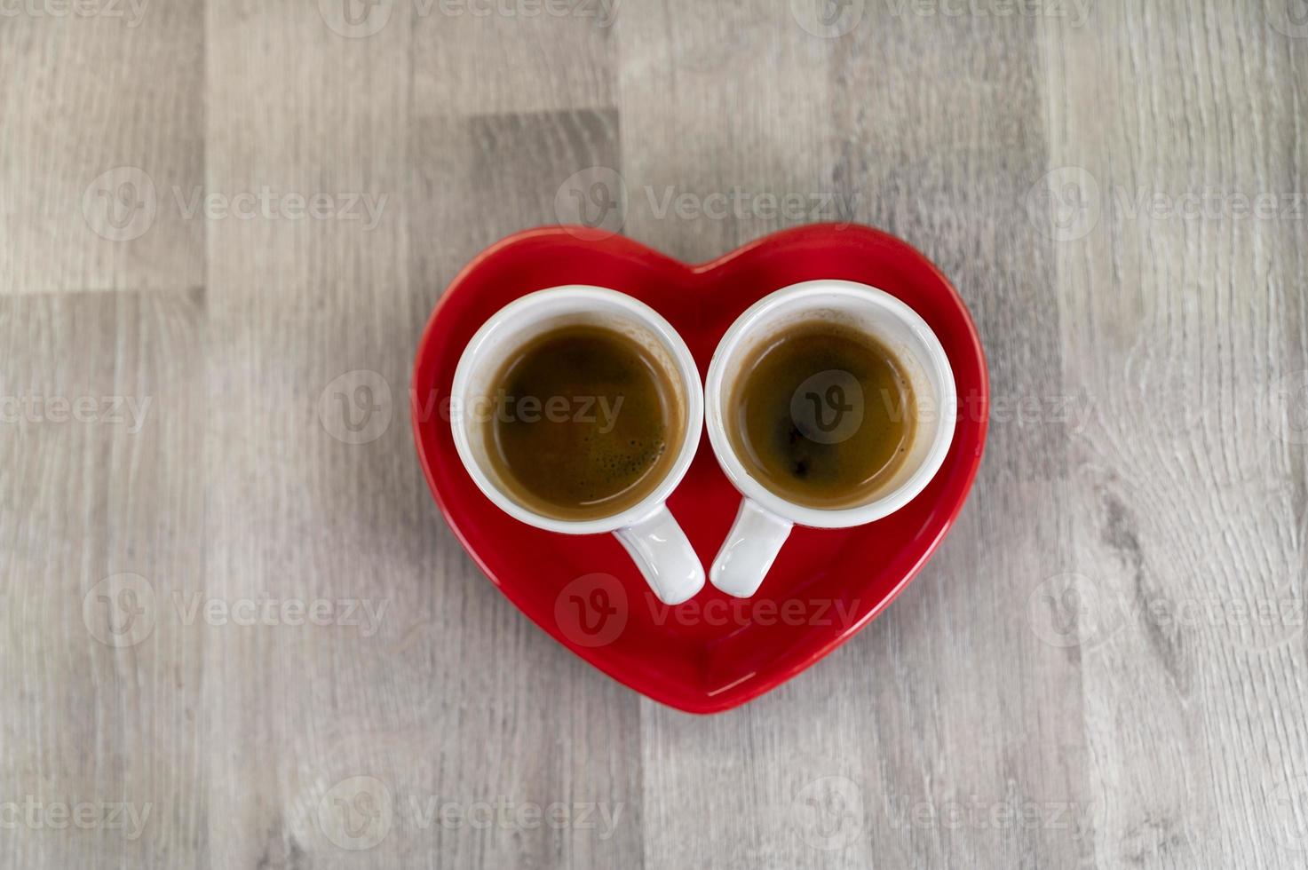 two small cups of coffee with a heart saucer photo