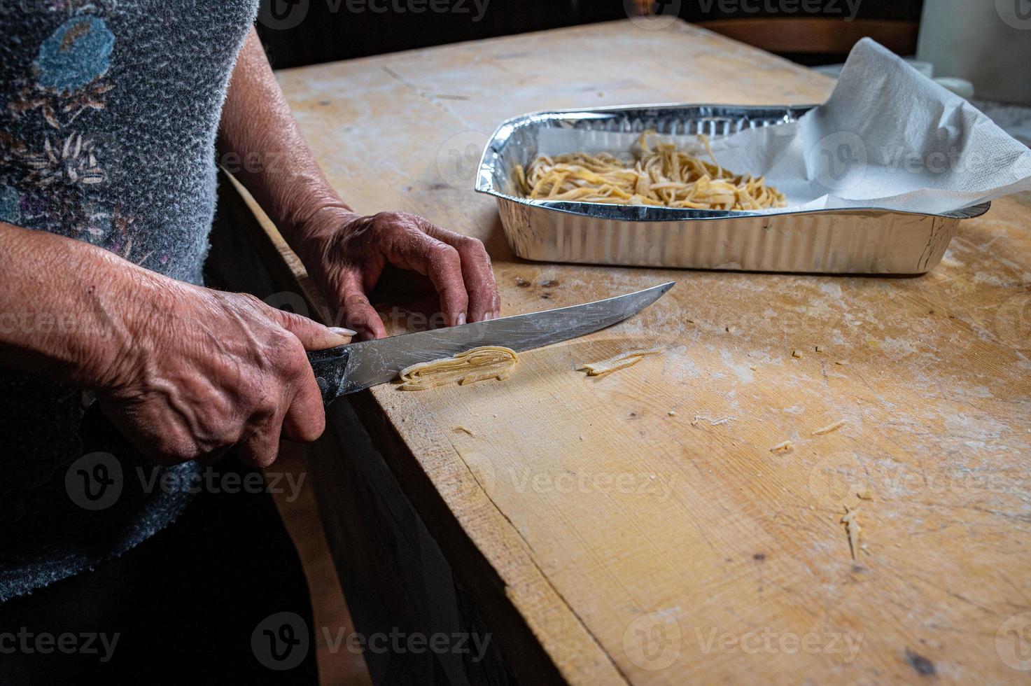 abuela prepara pasta de huevo casera foto