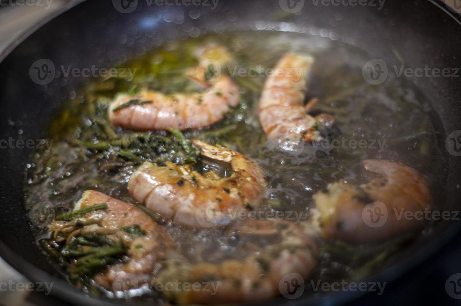 gambas fritas y espárragos en una sartén foto