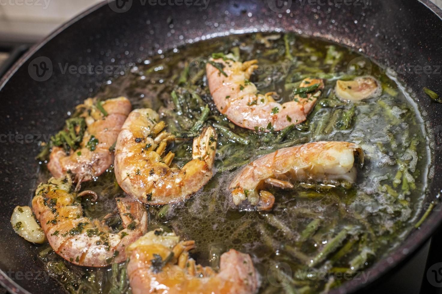 gambas fritas y espárragos en una sartén foto