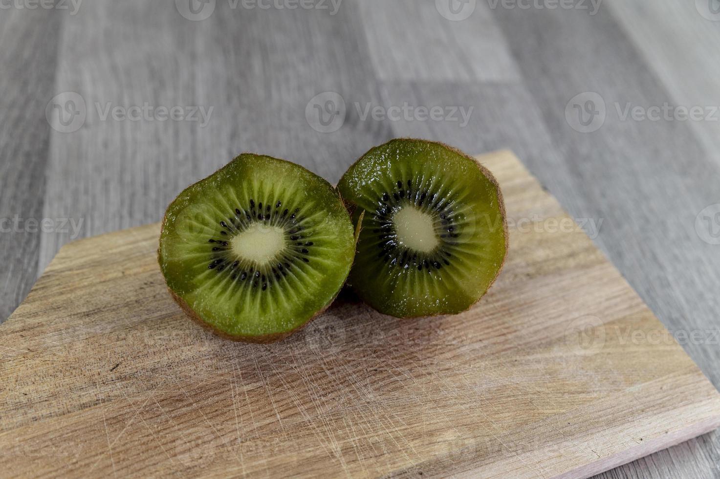 Composición con kiwi y una tabla de cortar de madera. foto