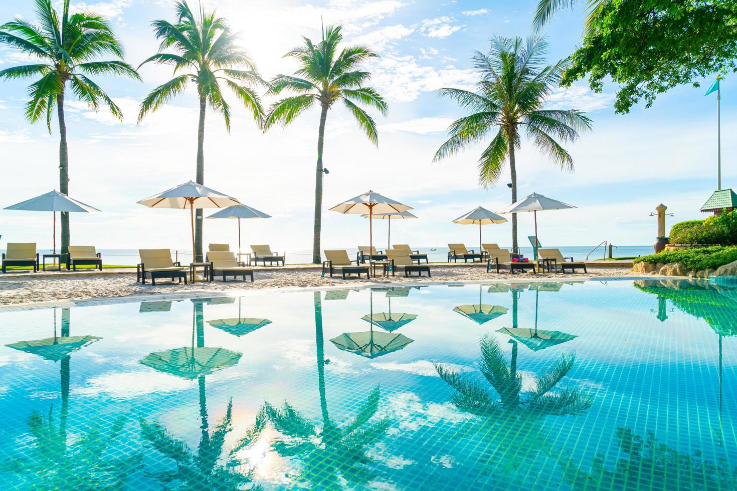 Beautiful umbrella and chair around swimming pool in hotel and resort photo