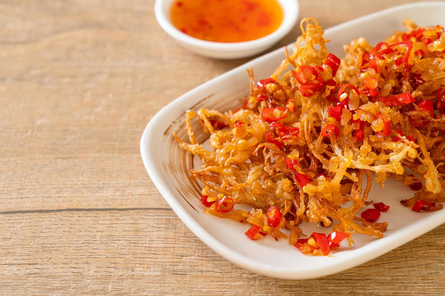 Seta enoki frita o seta de aguja dorada con sal y guindilla foto