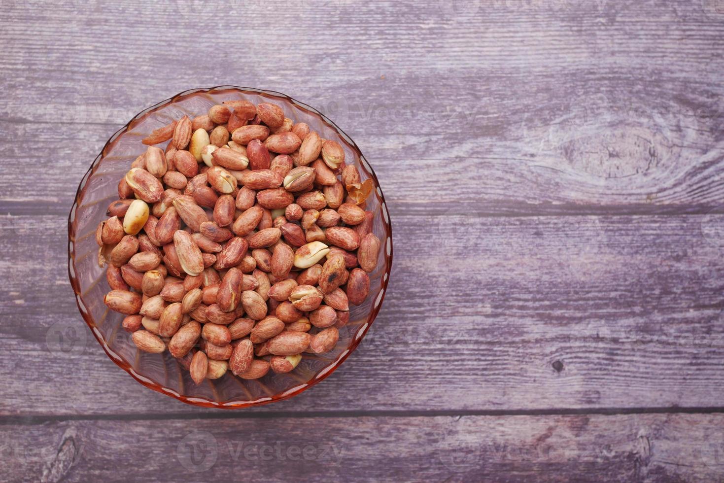 Processed pea nuts in a bowl on table top down . photo