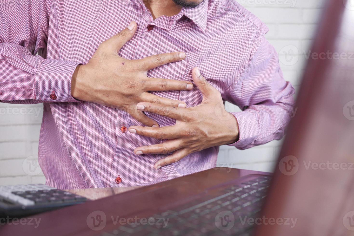 joven que sufre dolor en el corazón y sosteniendo el pecho con la mano foto