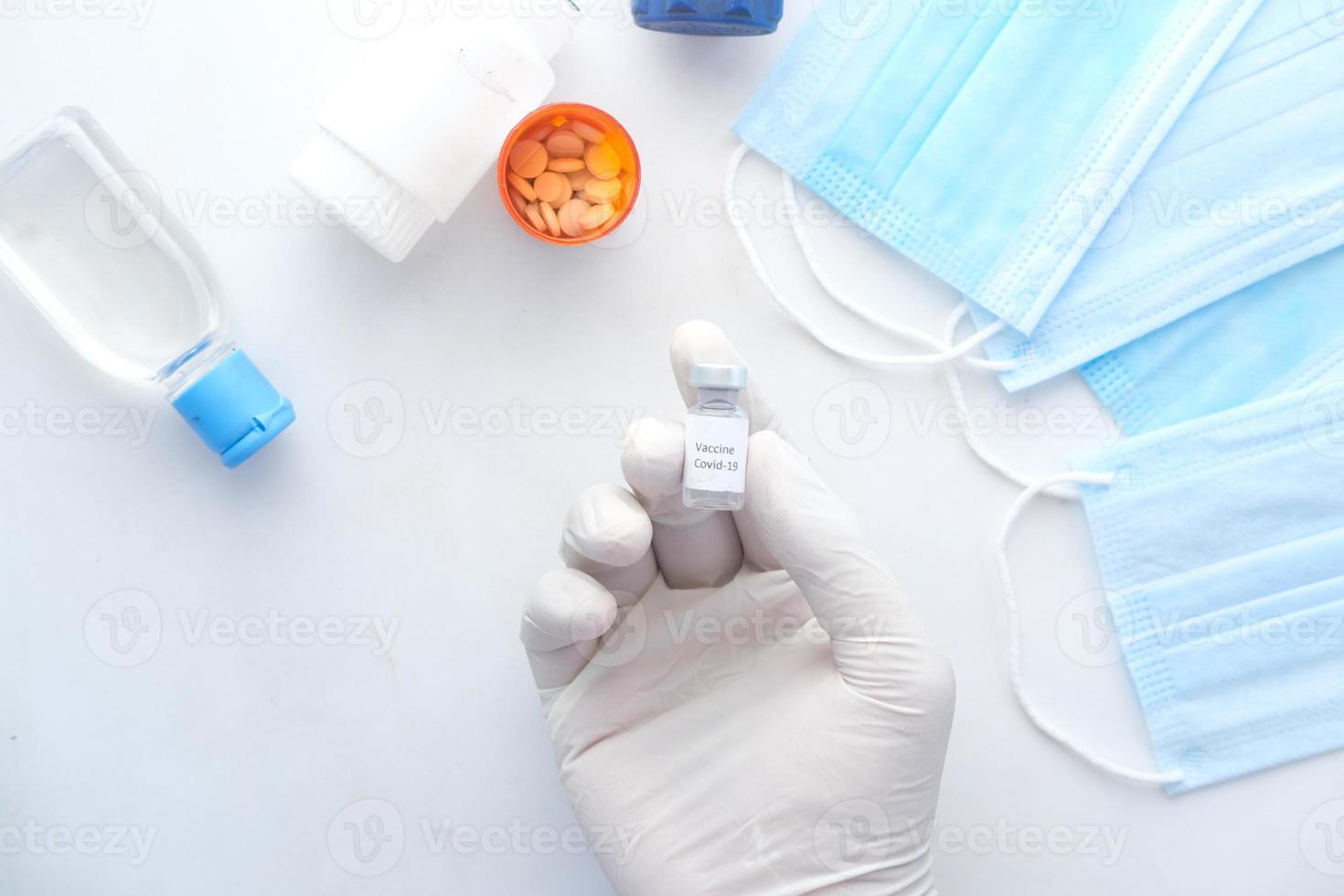 Hand in latex gloves holding glass ampoule vaccine, with copy space photo