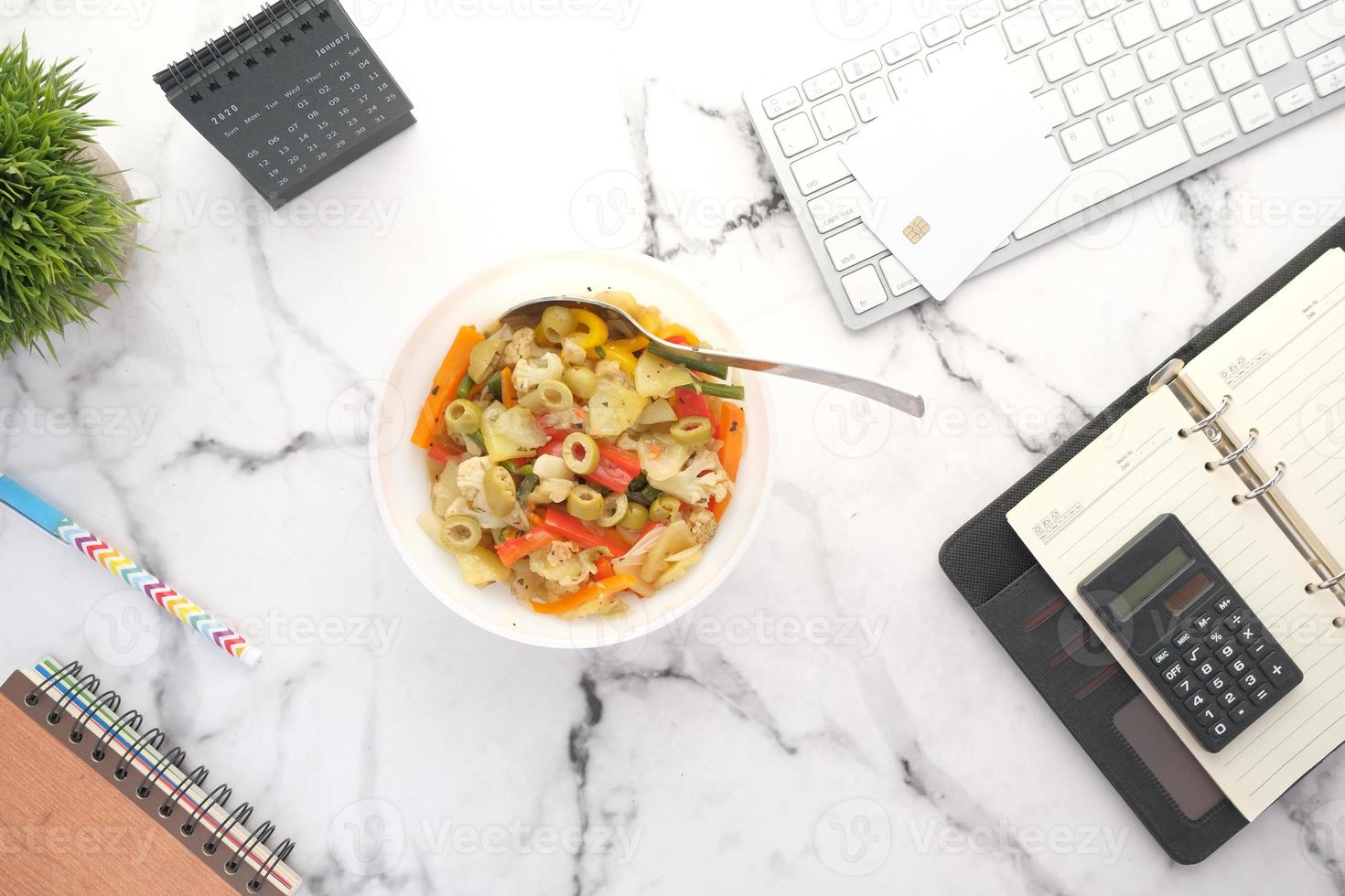 Harina de verduras frescas en un recipiente en el escritorio de oficina foto