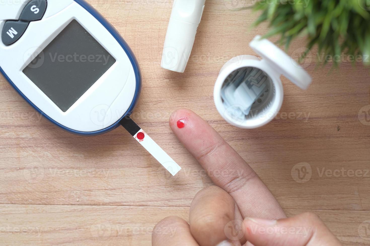 Man's hand measuring blood sugar level photo